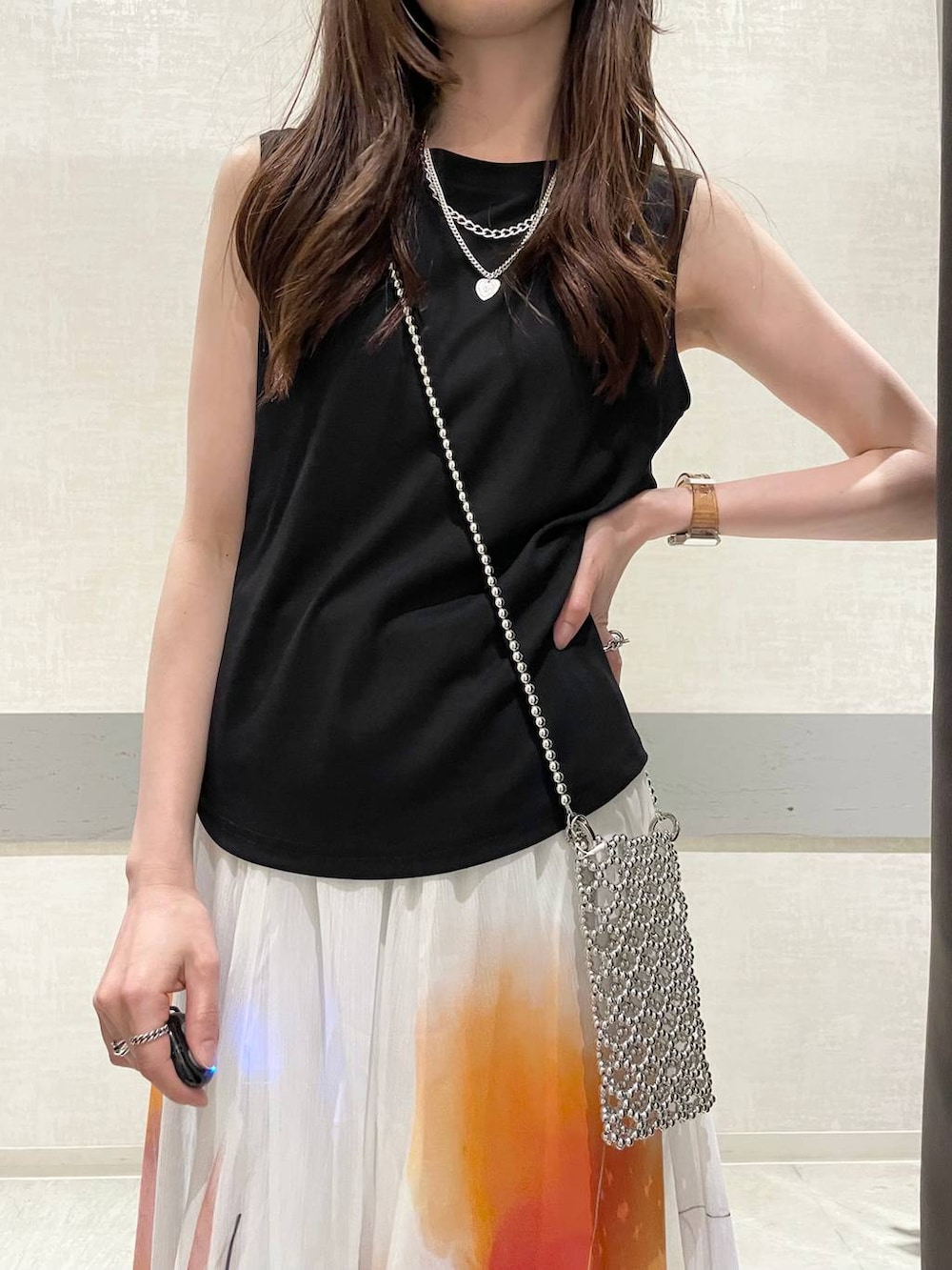 ホワイト系のスカート、ベージュ系のローファー、ブラック系のTシャツ/カットソーを着用したレディースの夏コーディネートの3枚目の写真