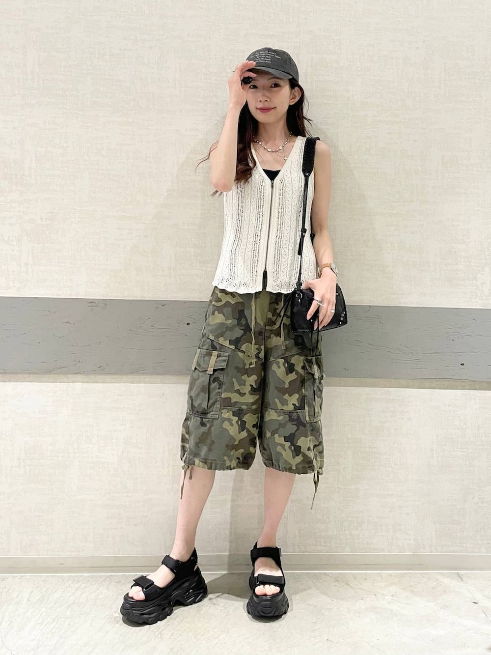 ブラック系のサンダル、グリーン系のTシャツ/カットソー、ホワイト系のベストを着用したレディースの夏コーディネートの2枚目の写真