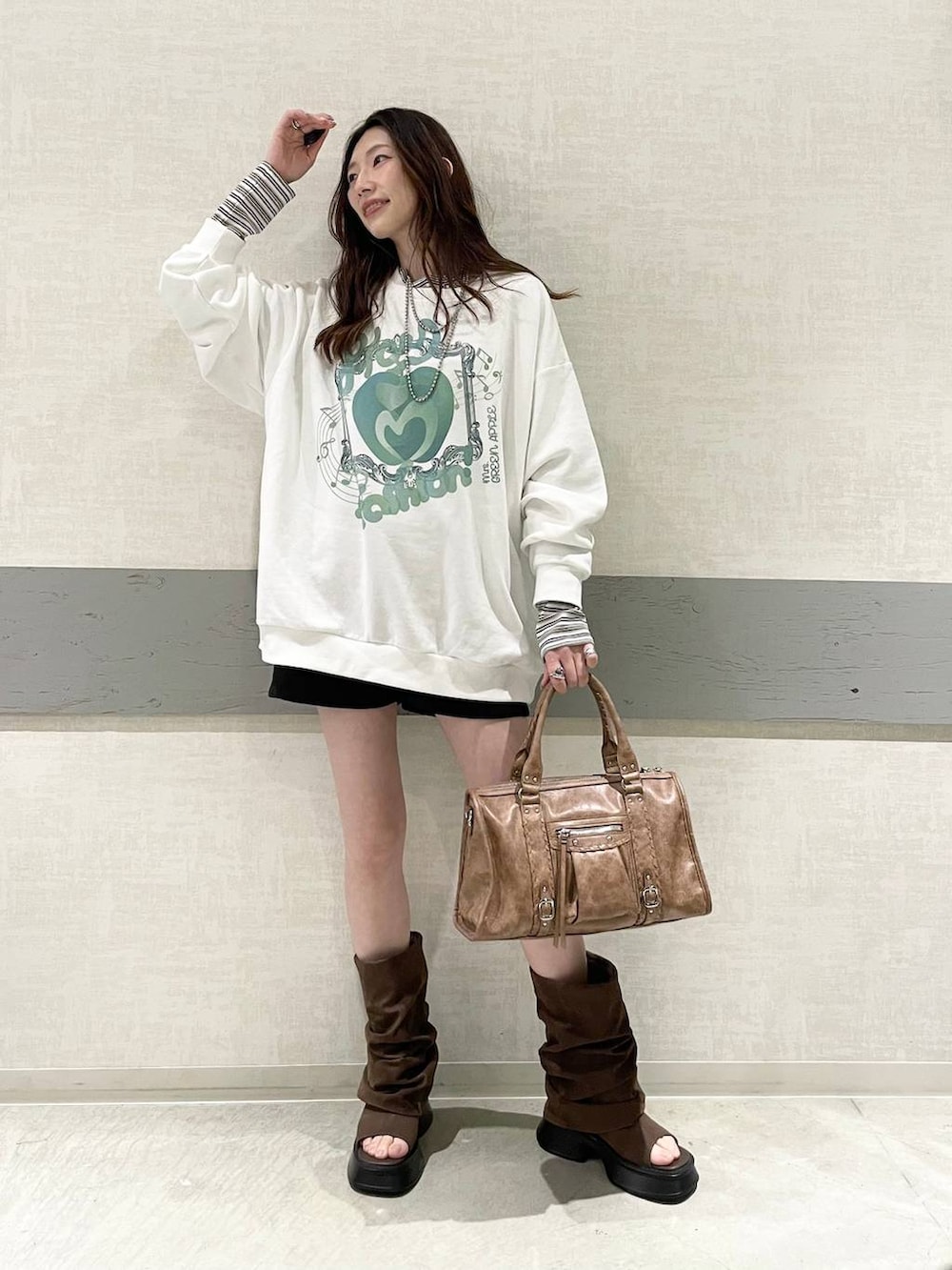 ホワイト系のTシャツ/カットソー、ブラック系のスウェットパンツ、ブラウン系のボストンバッグを着用したレディースの春コーディネートの2枚目の写真