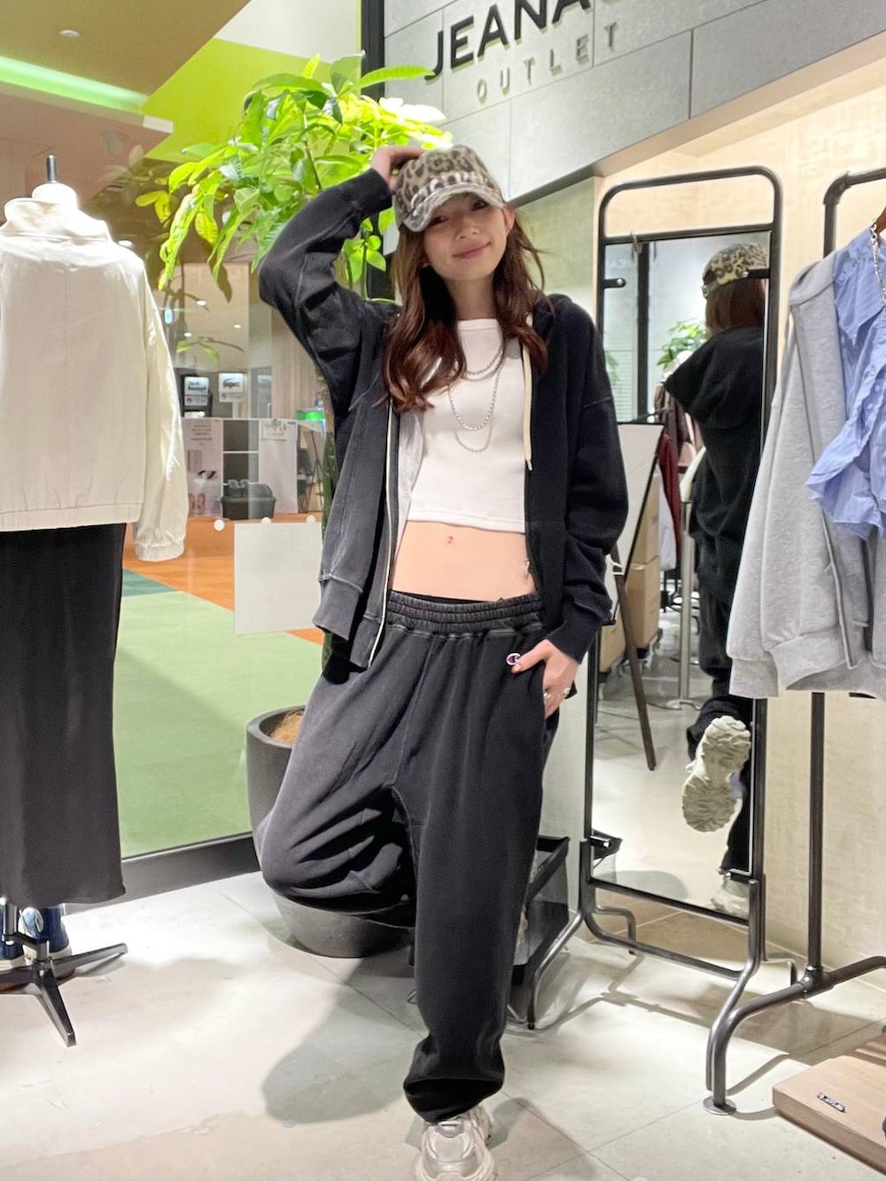 シルバー系のスニーカー、ブラック系のパーカー、ブラック系のスウェットパンツを着用したレディースの春コーディネートの2枚目の写真