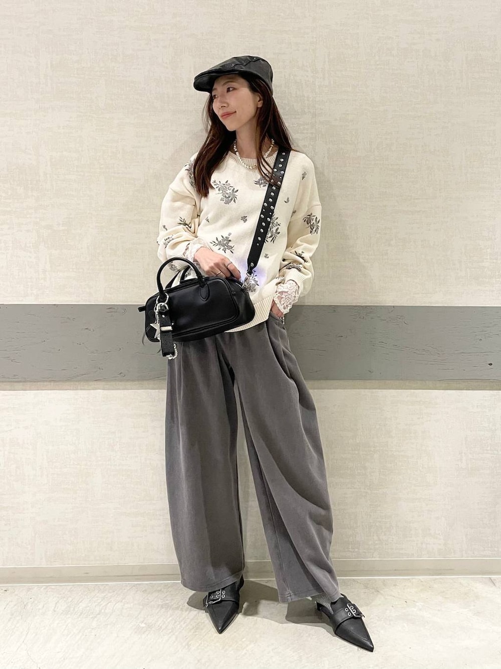 ブラック系のボストンバッグ、ブラック系のパンプス、ホワイト系のニット/セーターを着用したレディースの春コーディネートの5枚目の写真