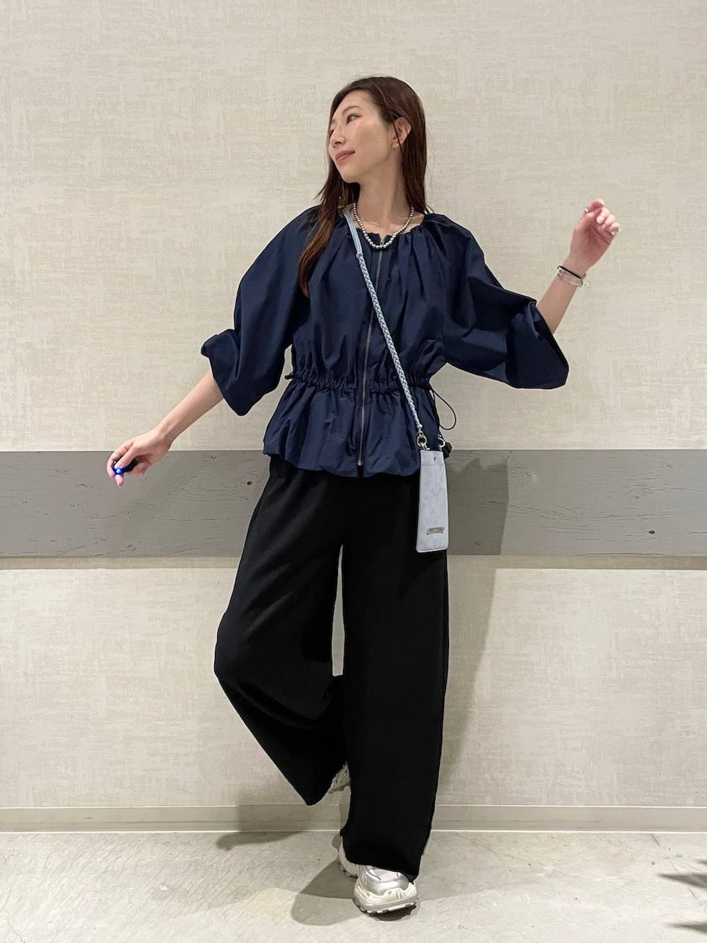 ホワイト系のスニーカー、ブラック系のその他パンツ、ブルー系のシャツ/ブラウスを着用したレディースの秋コーディネートの2枚目の写真