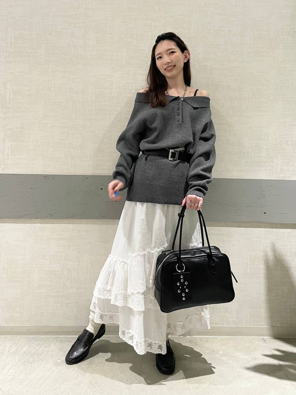 ブラック系のボストンバッグ、ブラック系のローファー、グレー系のニット/セーターを着用したレディースの冬コーディネートの2枚目の写真