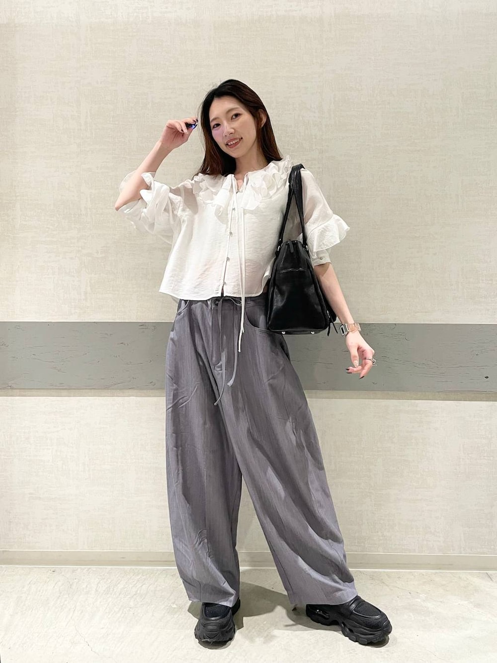 ブラック系のローファー、ブラック系のトートバッグ、グレー系のスラックスを着用したレディースの春コーディネートの5枚目の写真