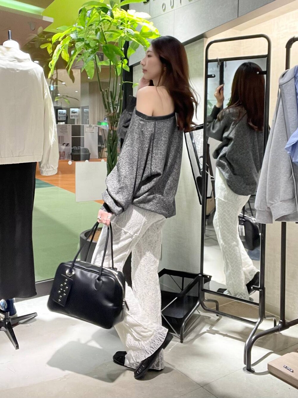 ブラック系のスウェット、ブラック系のボストンバッグ、ブラック系のローファーを着用したレディースの春コーディネートの3枚目の写真