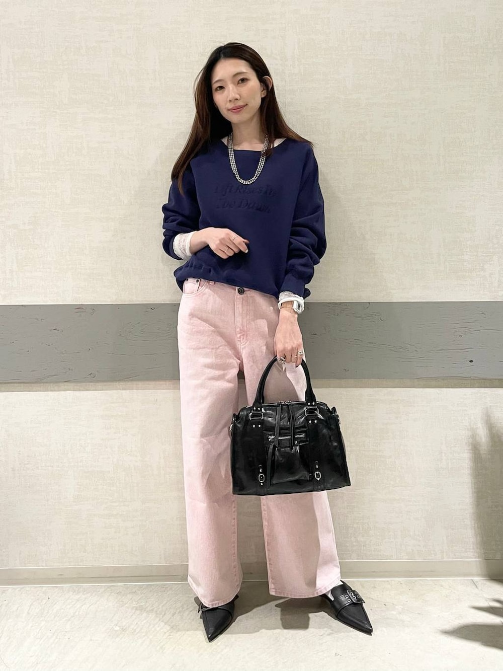 ブラック系のボストンバッグ、ブラック系のパンプス、ホワイト系のTシャツ/カットソーを着用したレディースの冬コーディネートの2枚目の写真