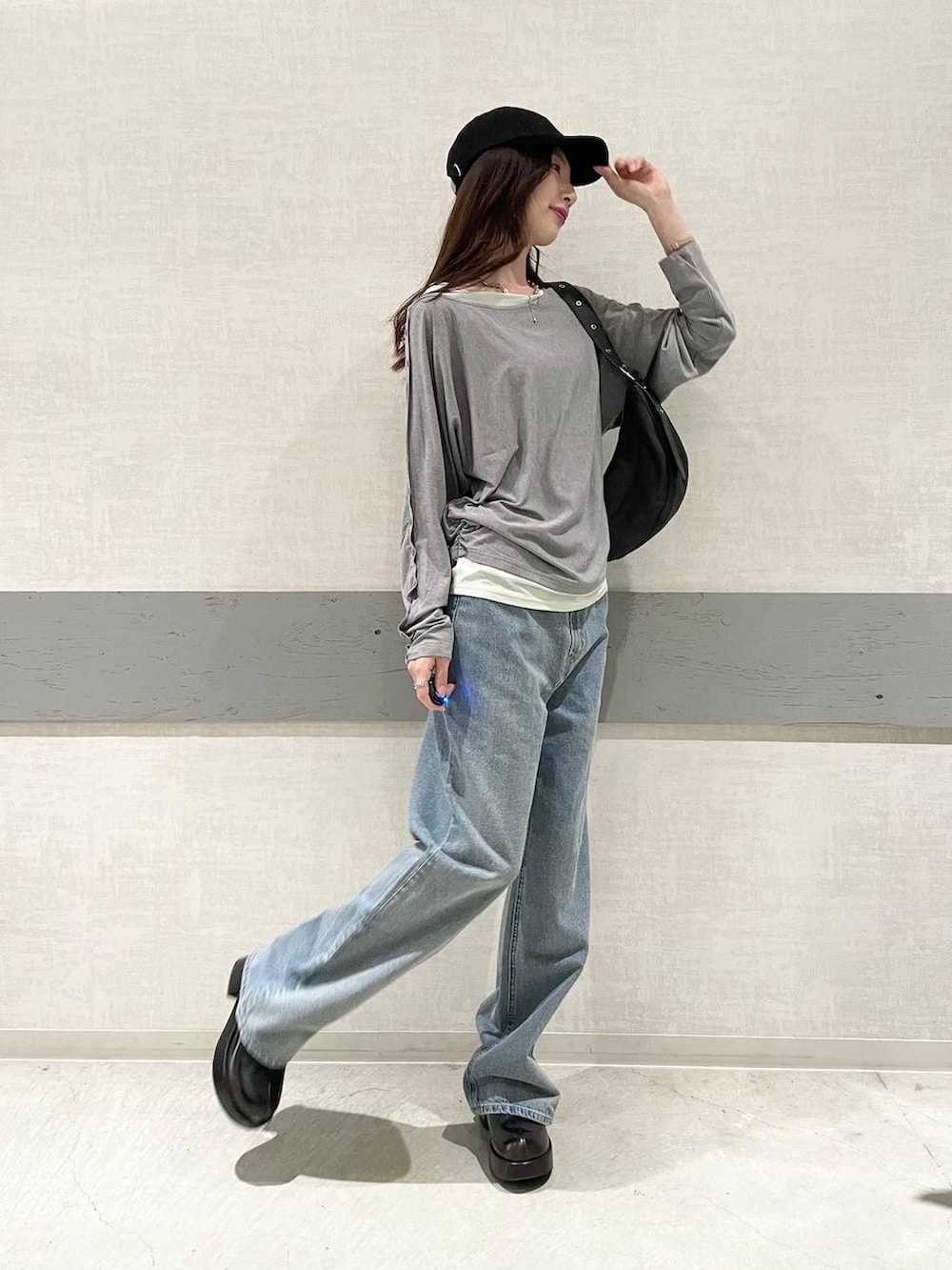 ブラック系のデニムパンツ、ブラック系のショルダーバッグ、グレー系のTシャツ/カットソーを着用したレディースの夏コーディネートの5枚目の写真