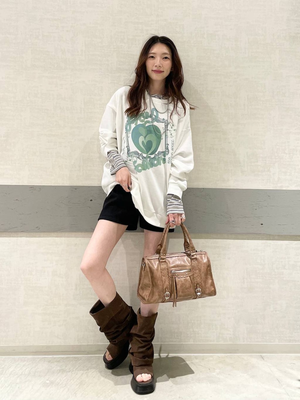 ホワイト系のTシャツ/カットソー、ブラック系のスウェットパンツ、ブラウン系のボストンバッグを着用したレディースの春コーディネートの7枚目の写真