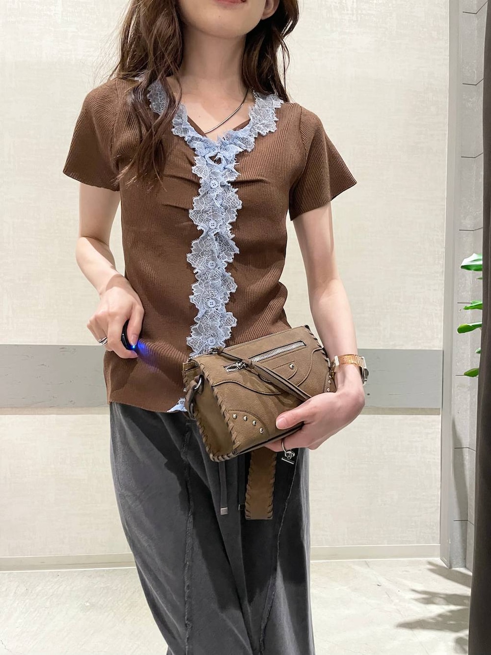 ブラック系のスカート、ブラウン系のショルダーバッグ、ブラック系のサンダルを着用したレディースの夏コーディネートの5枚目の写真