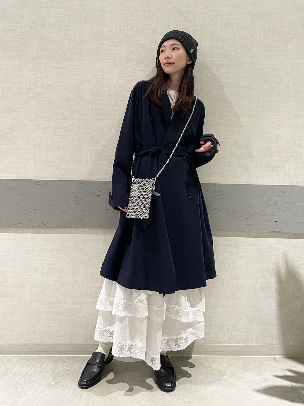 ホワイト系のTシャツ/カットソー、ブルー系のトレンチコート、ブラック系のローファーを着用したレディースの冬コーディネートの2枚目の写真