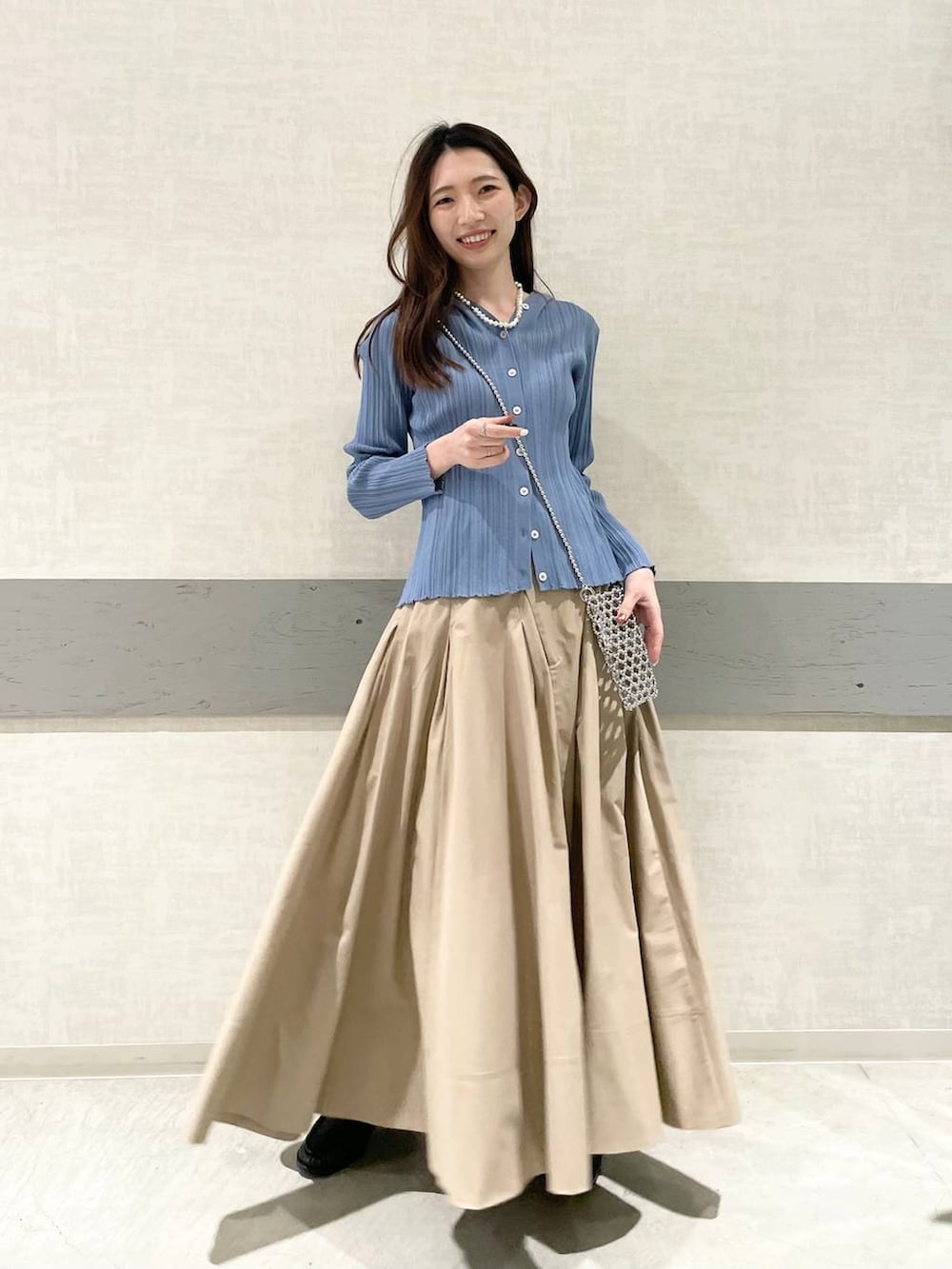ベージュ系のスカート、ブラック系のローファー、ブルー系のカーディガン/ボレロを着用したレディースの春コーディネートの3枚目の写真