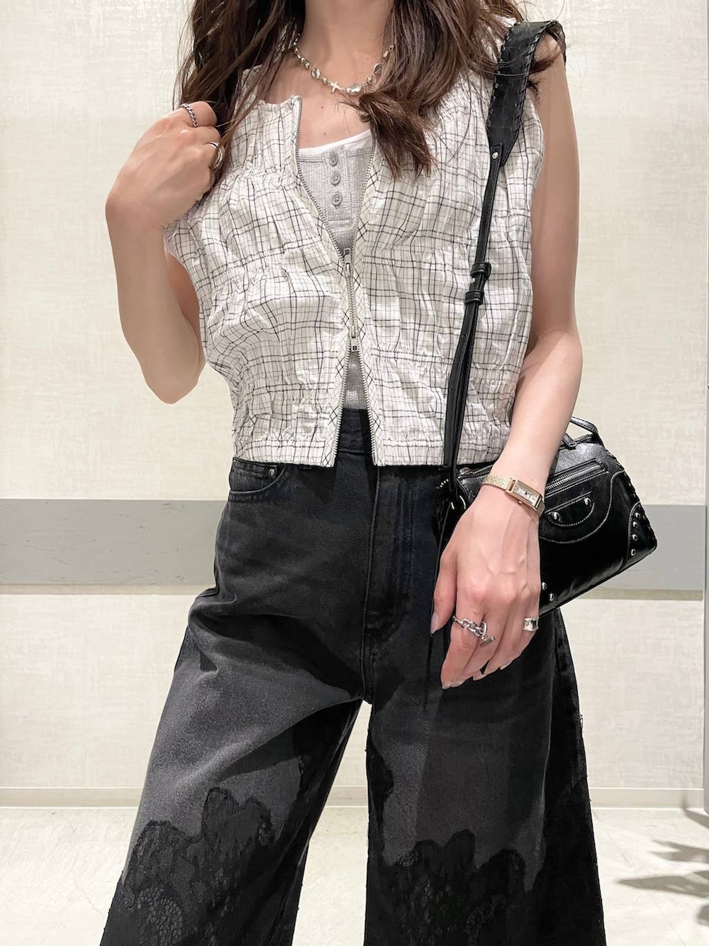 ブラック系のデニムパンツ、ホワイト系のベスト、グレー系のタンクトップを着用したレディースの夏コーディネートの5枚目の写真