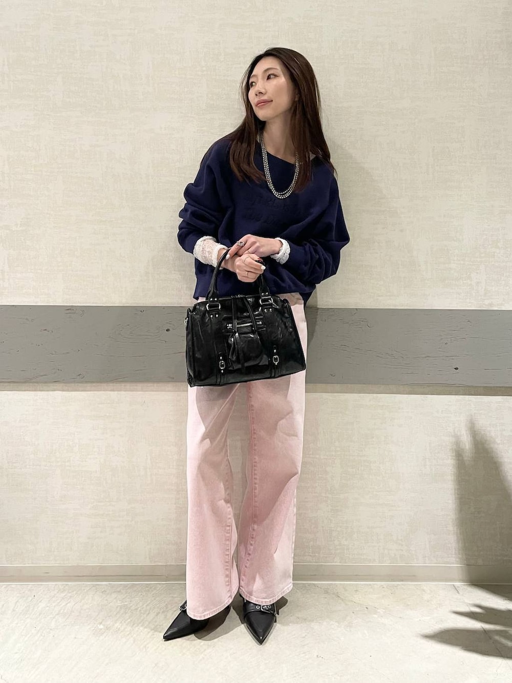 ブラック系のボストンバッグ、ブラック系のパンプス、ホワイト系のTシャツ/カットソーを着用したレディースの冬コーディネートの5枚目の写真