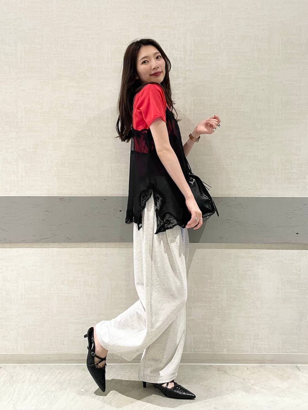 ブラック系のボストンバッグ、ブラック系のパンプス、レッド系のTシャツ/カットソーを着用したレディースの夏コーディネートの2枚目の写真