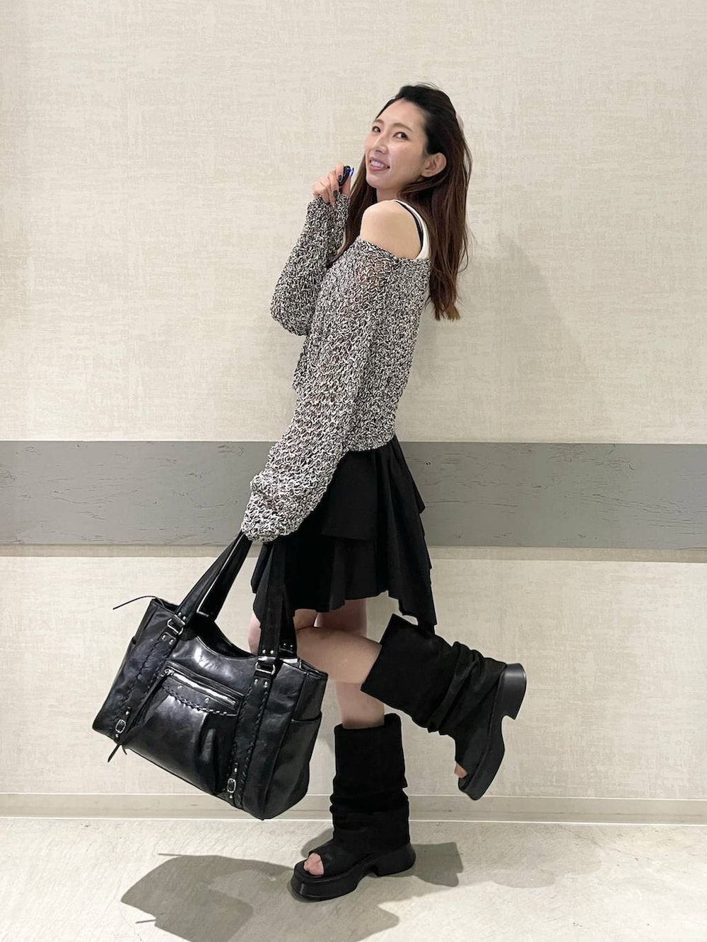 ホワイト系のタンクトップ、ブラック系のトートバッグ、ブラック系のスカートを着用したレディースの春コーディネートの3枚目の写真