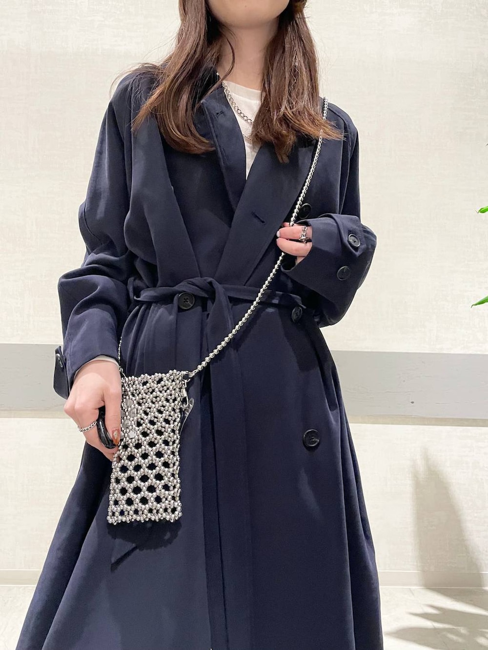 ホワイト系のTシャツ/カットソー、ブルー系のトレンチコート、ブラック系のローファーを着用したレディースの冬コーディネートの6枚目の写真