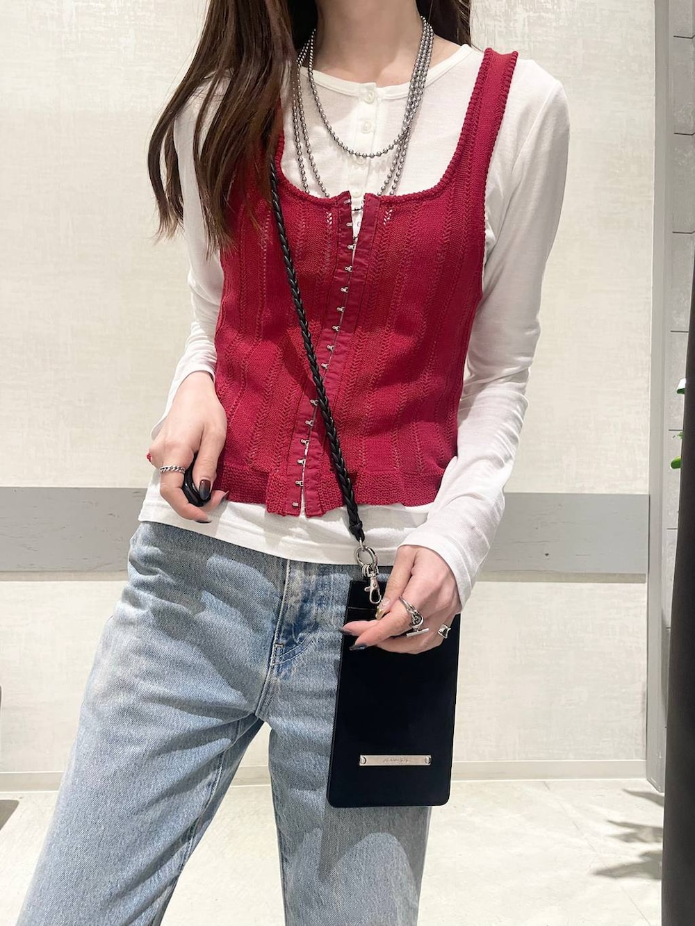 ホワイト系のTシャツ/カットソー、シルバー系のスニーカー、レッド系のベストを着用したレディースの春コーディネートの3枚目の写真