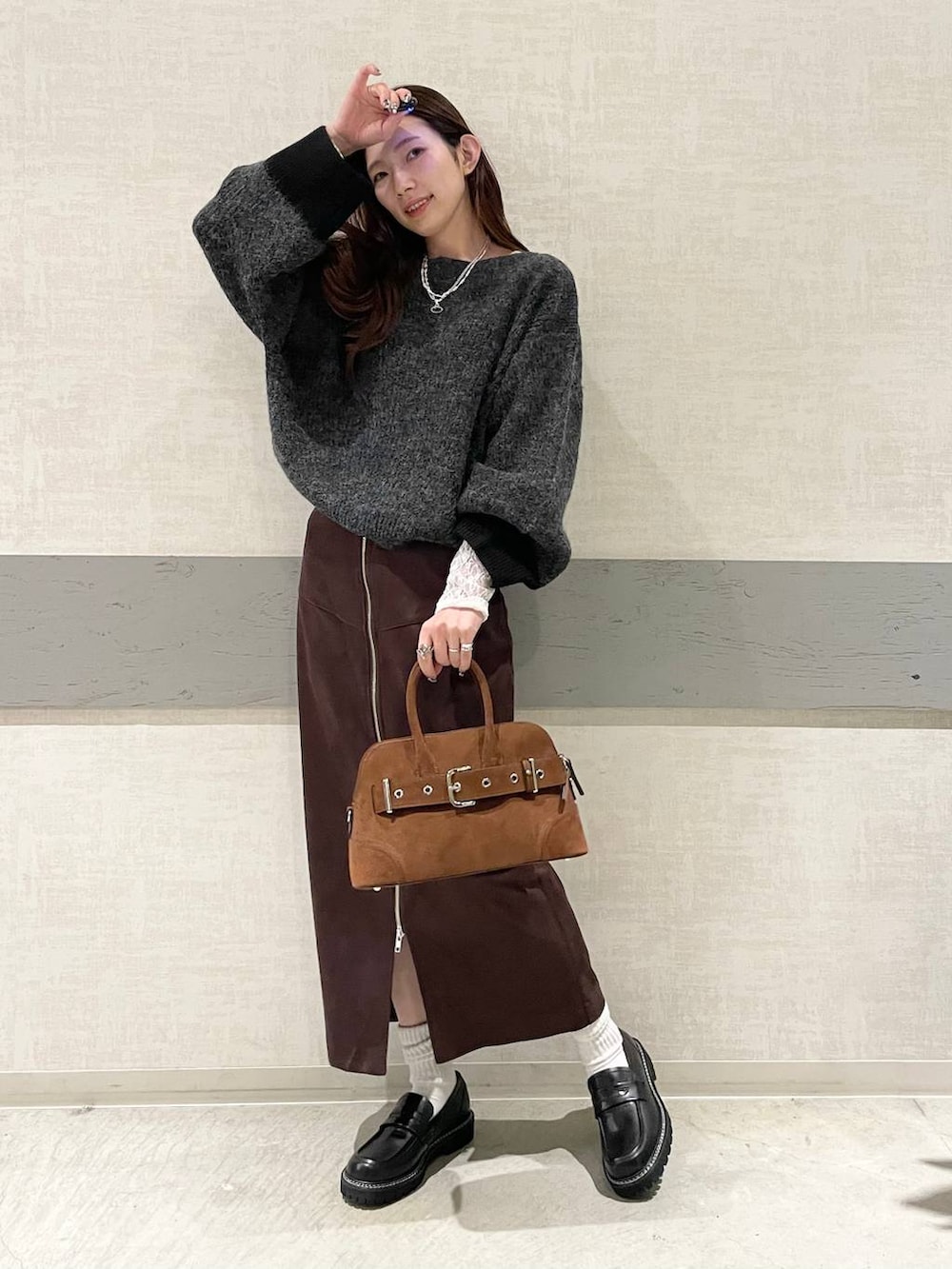 ブラウン系のスカート、ブラック系のローファー、ブラウン系のボストンバッグを着用したレディースの秋コーディネートの2枚目の写真