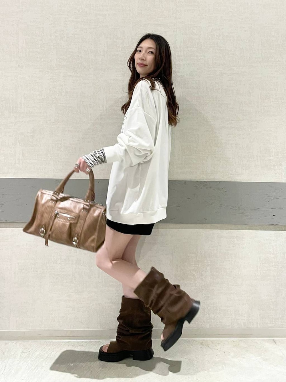 ホワイト系のTシャツ/カットソー、ブラック系のスウェットパンツ、ブラウン系のボストンバッグを着用したレディースの春コーディネートの6枚目の写真