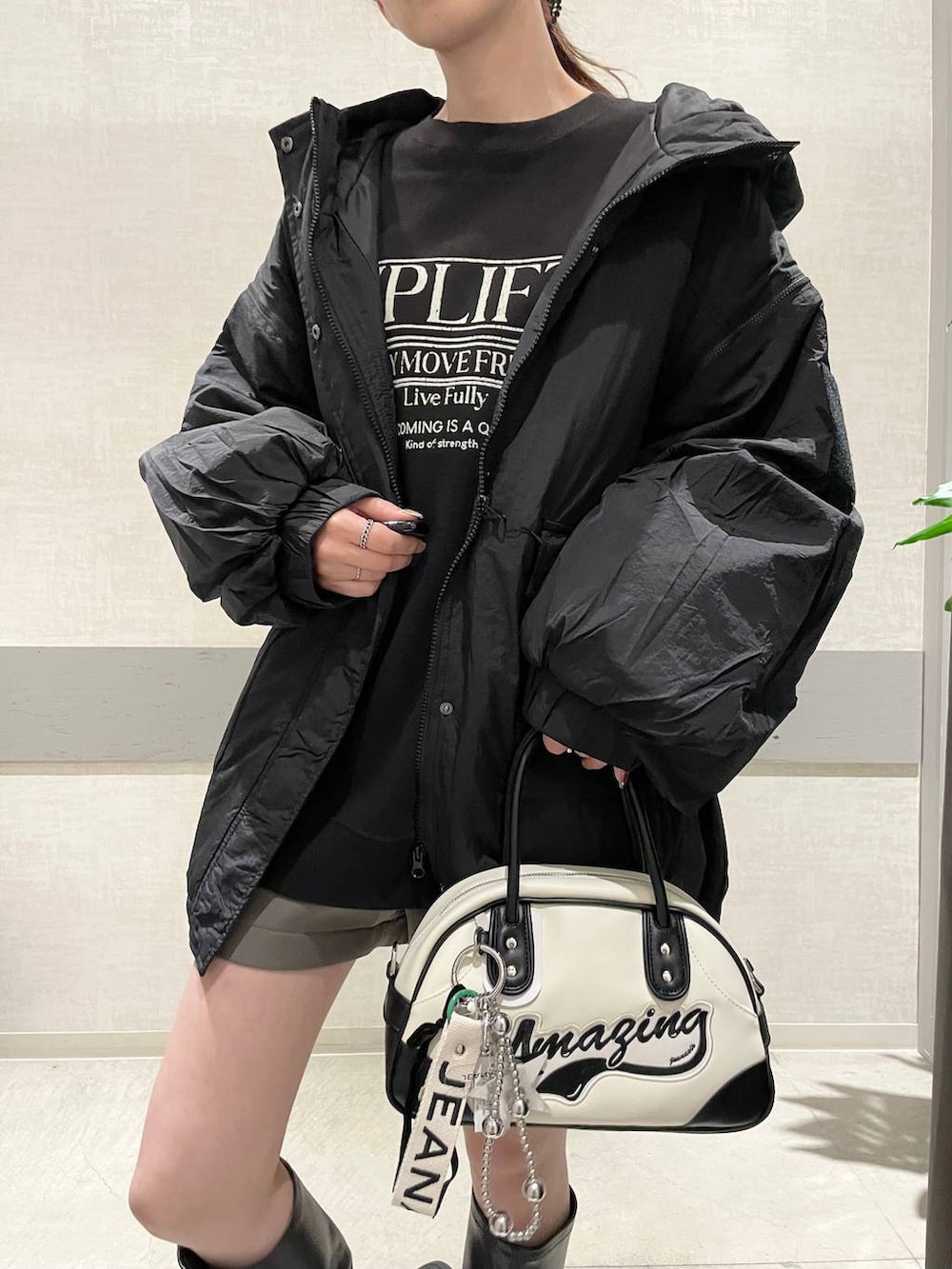 ブラック系のブルゾン、ホワイト系のショルダーバッグ、グレー系のその他パンツを着用したレディースの秋コーディネートの3枚目の写真