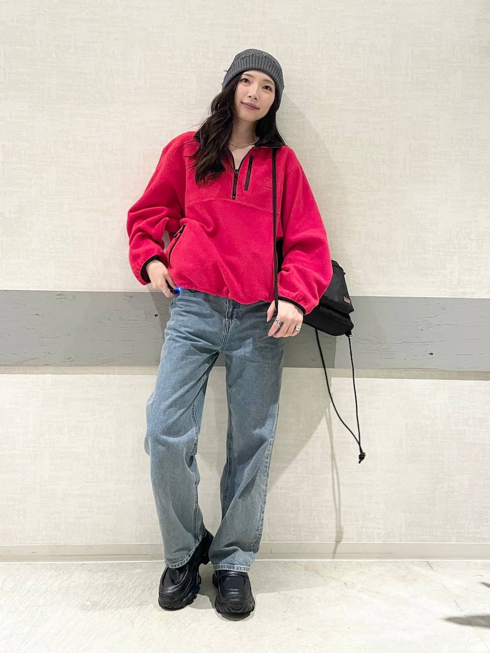 ブルー系のデニムパンツ、レッド系のその他アウター、ブラック系のバックパック/リュックを着用したレディースの秋コーディネートの2枚目の写真