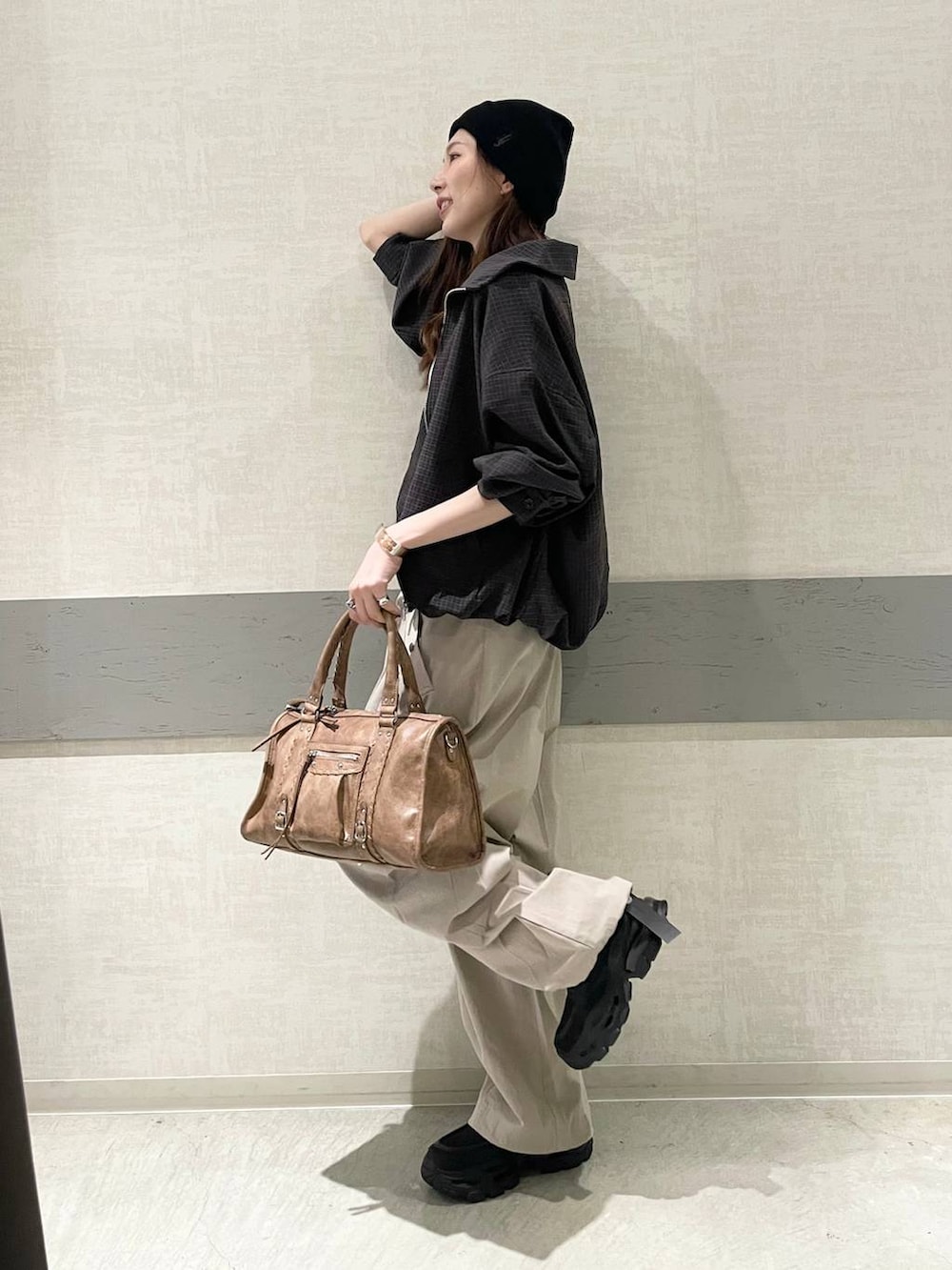 ホワイト系のタンクトップ、ブラック系のローファー、ブラウン系のボストンバッグを着用したレディースの春コーディネートの6枚目の写真