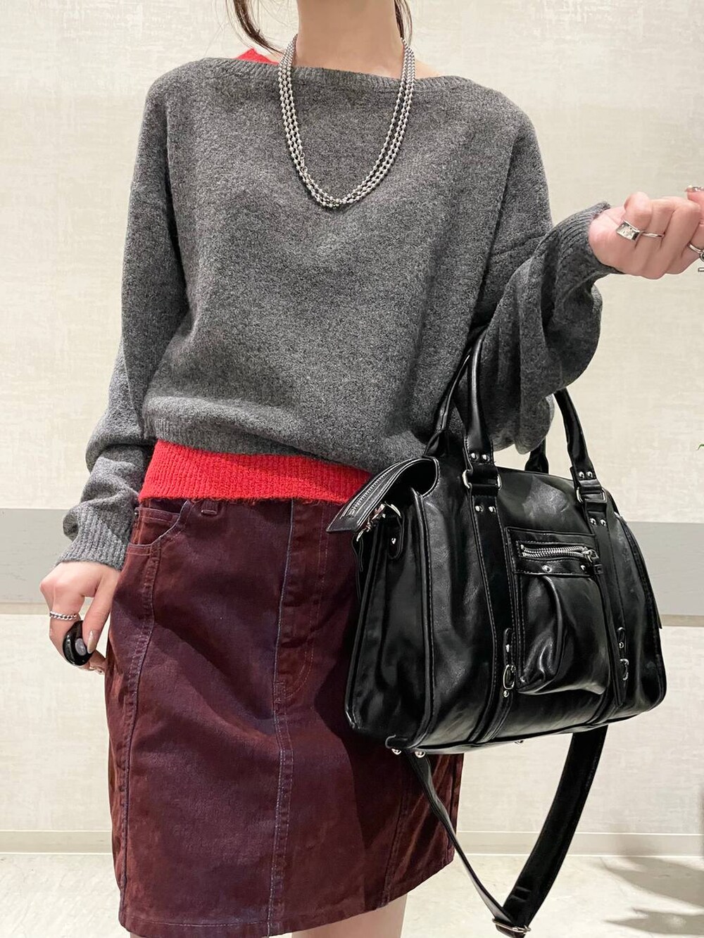 ブラック系のボストンバッグ、グレー系のブーツ、グレー系のニット/セーターを着用したレディースの冬コーディネートの4枚目の写真