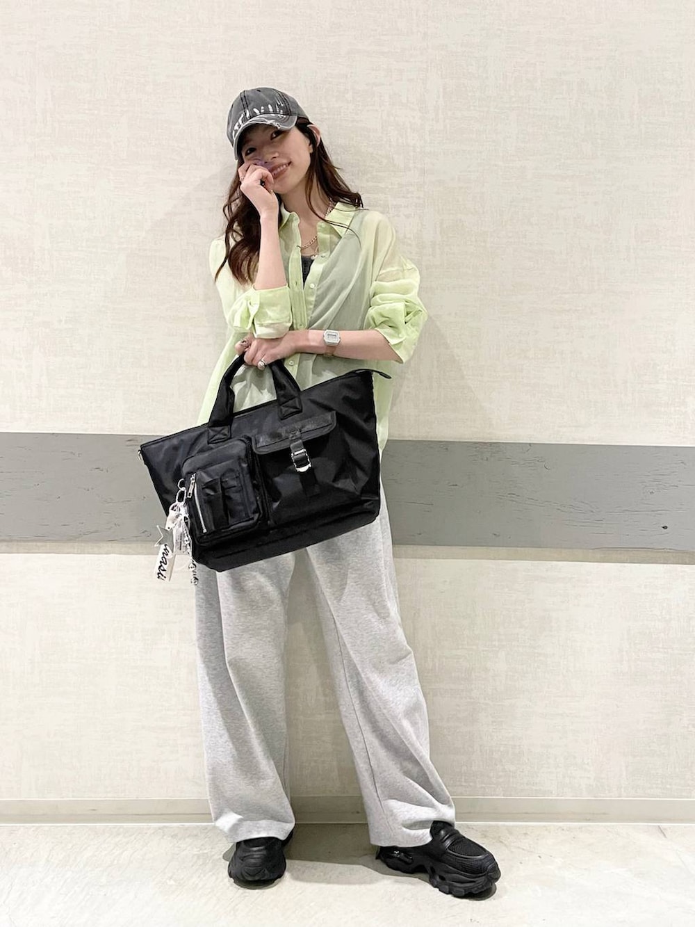 ブラック系のローファー、ブラック系のトートバッグ、グリーン系のシャツ/ブラウスを着用したレディースの春コーディネートの5枚目の写真