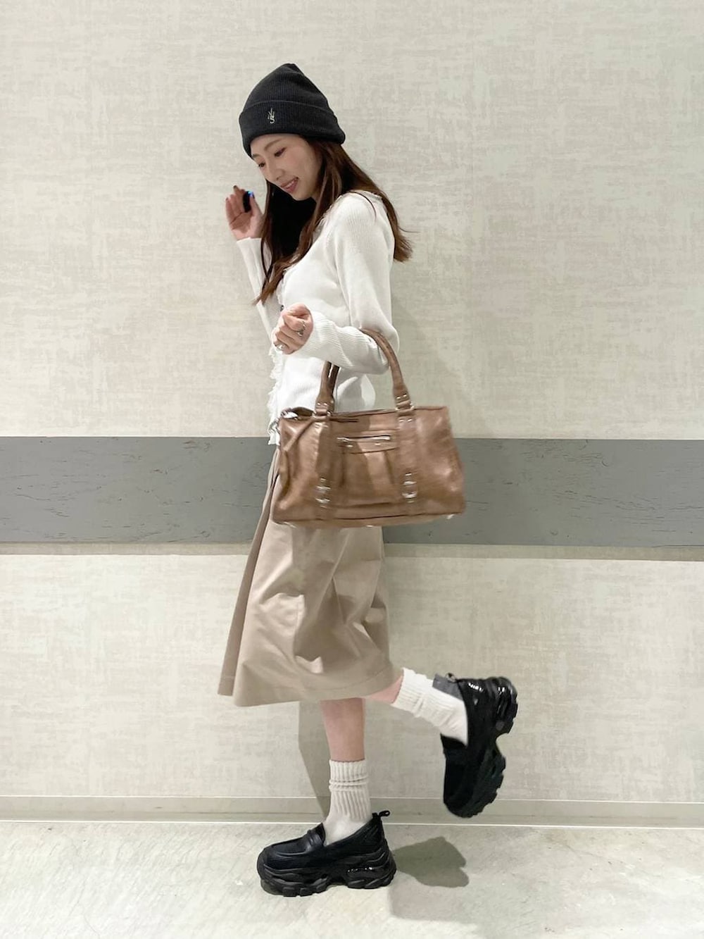 ブラック系のローファー、ブラウン系のボストンバッグ、ベージュ系のその他パンツを着用したレディースの春コーディネートの3枚目の写真