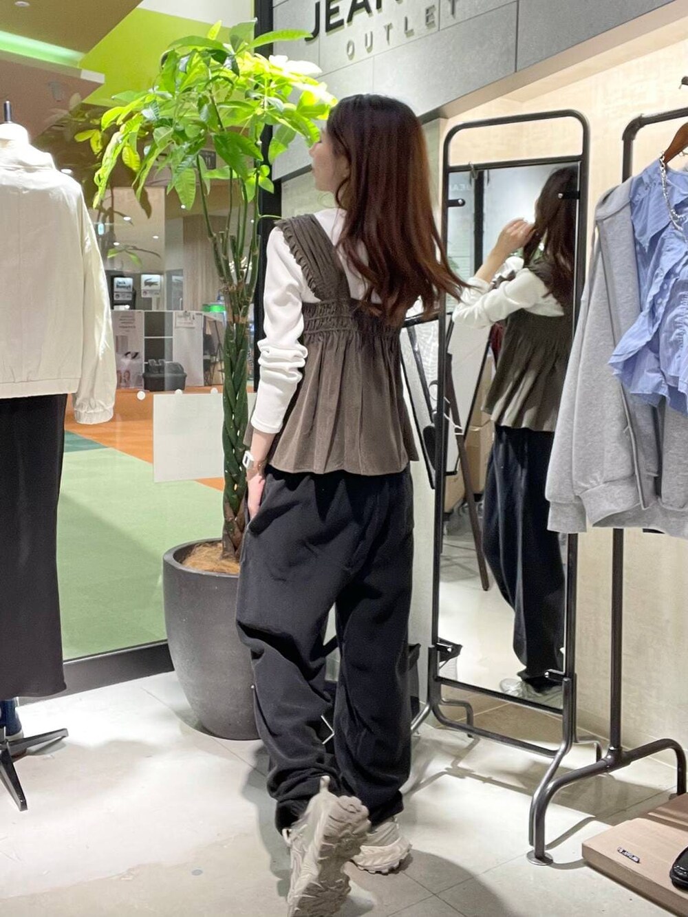 シルバー系のスニーカー、ブラック系のスウェットパンツ、ホワイト系のTシャツ/カットソーを着用したレディースの春コーディネートの3枚目の写真