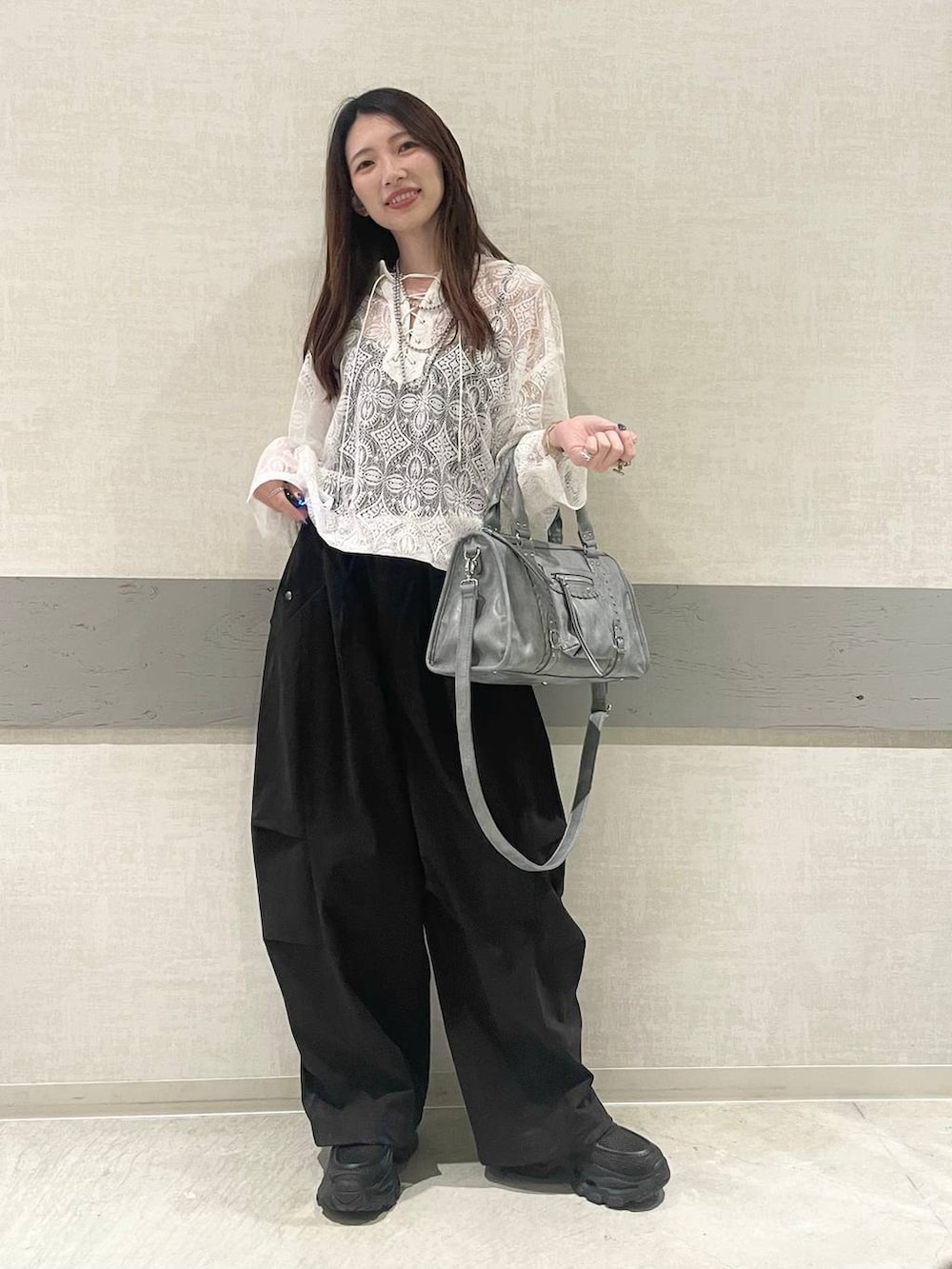 ブラック系のローファー、ブルー系のボストンバッグ、ホワイト系のパーカーを着用したレディースの春コーディネートの5枚目の写真