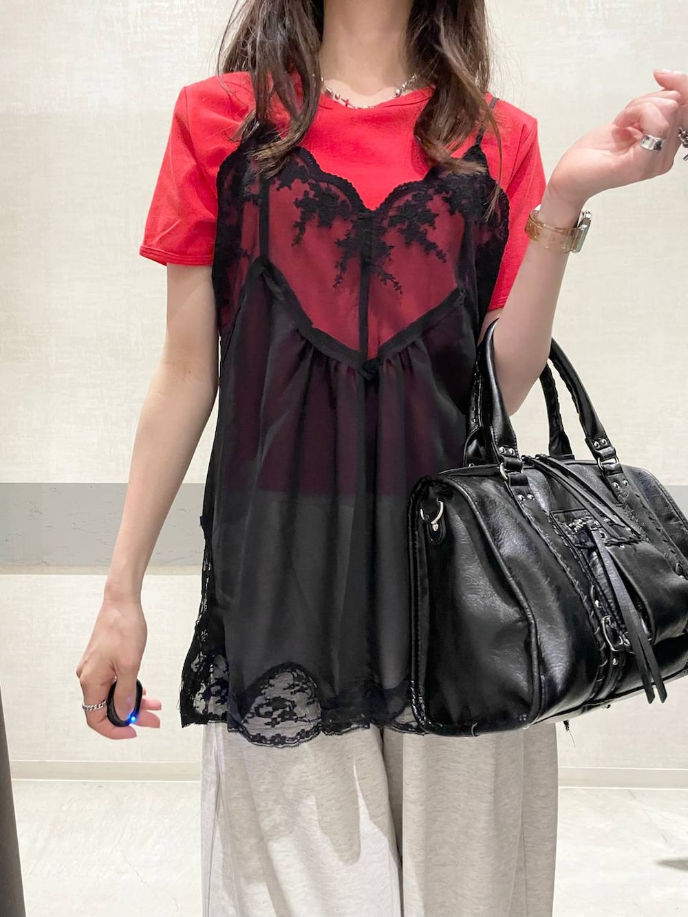 ブラック系のボストンバッグ、ブラック系のパンプス、レッド系のTシャツ/カットソーを着用したレディースの夏コーディネートの5枚目の写真