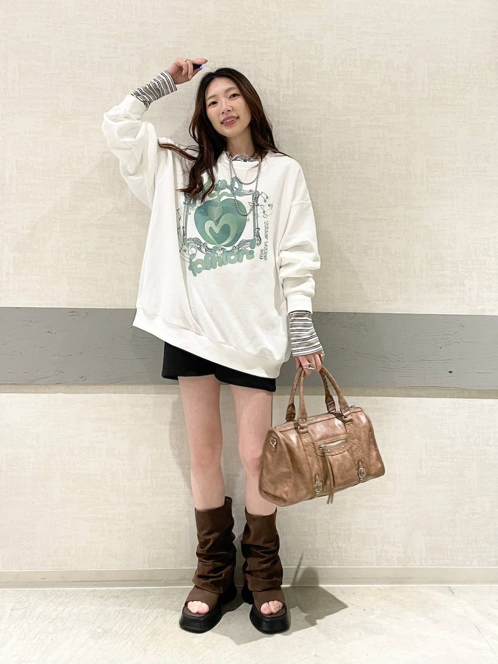 ホワイト系のTシャツ/カットソー、ブラック系のスウェットパンツ、ブラウン系のボストンバッグを着用したレディースの春コーディネートの4枚目の写真