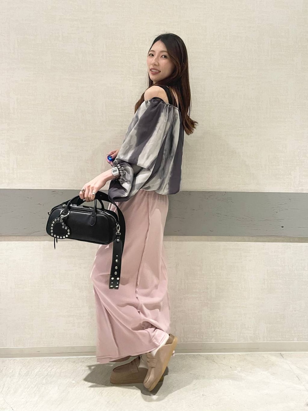 ブラック系のボストンバッグ、ベージュ系のローファー、ピンク系のスカートを着用したレディースの春コーディネートの5枚目の写真