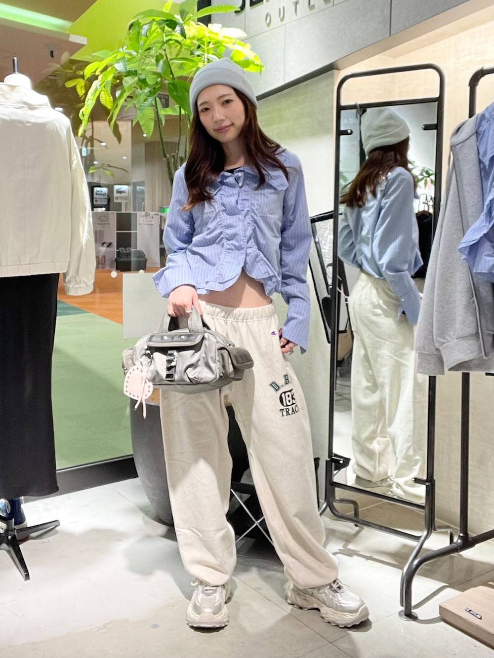 シルバー系のスニーカー、ベージュ系のスウェットパンツ、グリーン系のボストンバッグを着用したレディースの春コーディネートの5枚目の写真