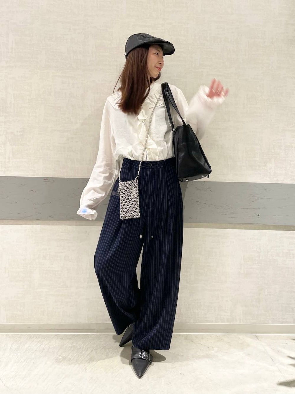 ブラック系のパンプス、ブルー系のスラックス、ブラック系のトートバッグを着用したレディースの春コーディネートの3枚目の写真