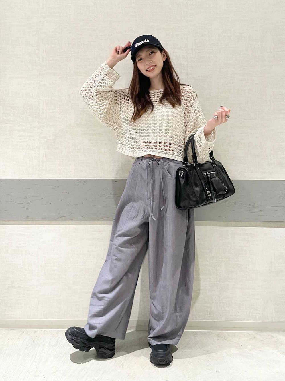 ブラック系のローファー、ブラック系のボストンバッグ、ピンク系のニット/セーターを着用したレディースの春コーディネートの3枚目の写真