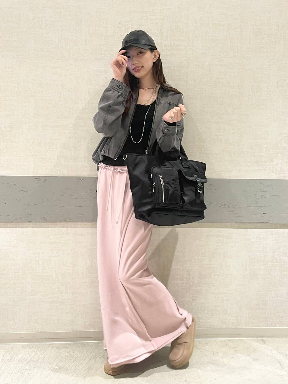 ブラック系のトートバッグ、ベージュ系のローファー、ブラック系のブルゾンを着用したレディースの春コーディネートの5枚目の写真