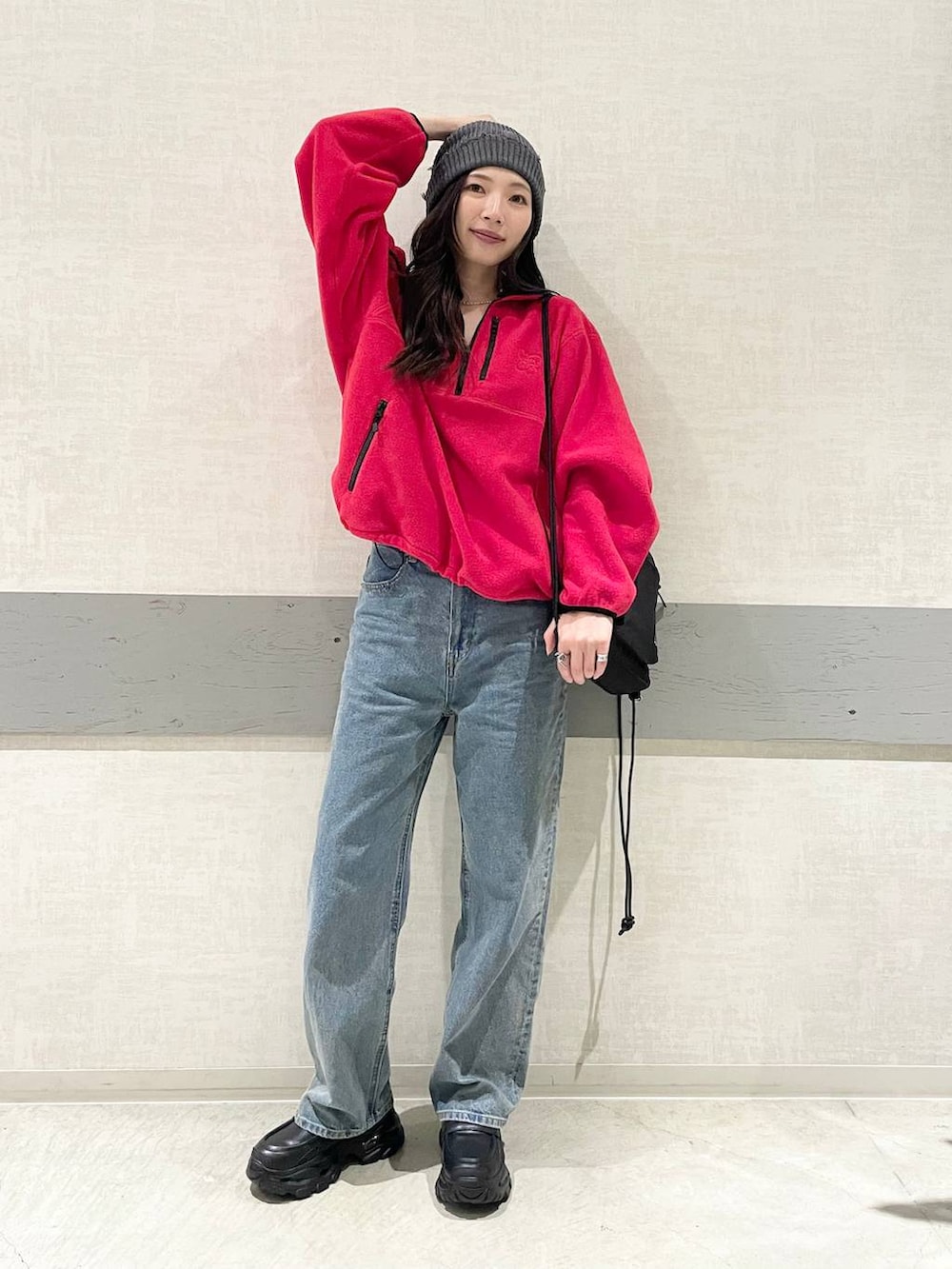 ブルー系のデニムパンツ、レッド系のその他アウター、ブラック系のバックパック/リュックを着用したレディースの秋コーディネートの4枚目の写真
