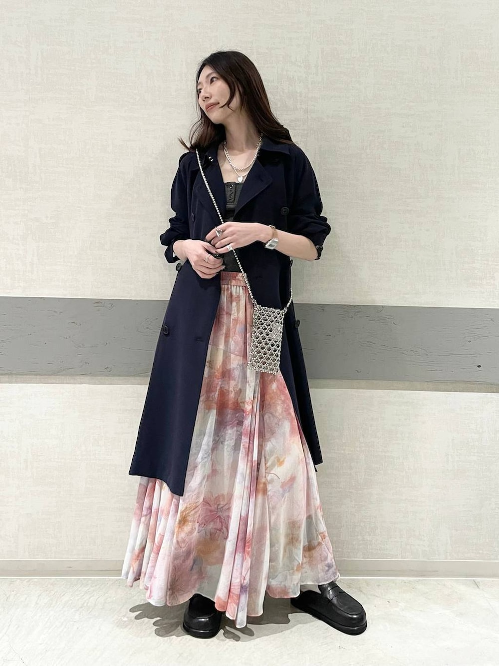 ブルー系のトレンチコート、ブラック系のローファー、レッド系のスカートを着用したレディースの春コーディネートの2枚目の写真