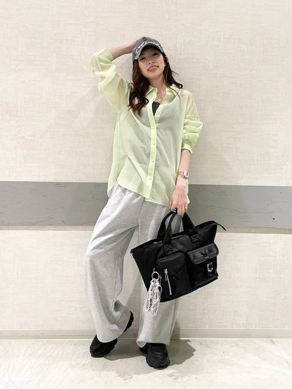 ブラック系のローファー、ブラック系のトートバッグ、グリーン系のシャツ/ブラウスを着用したレディースの春コーディネートの3枚目の写真