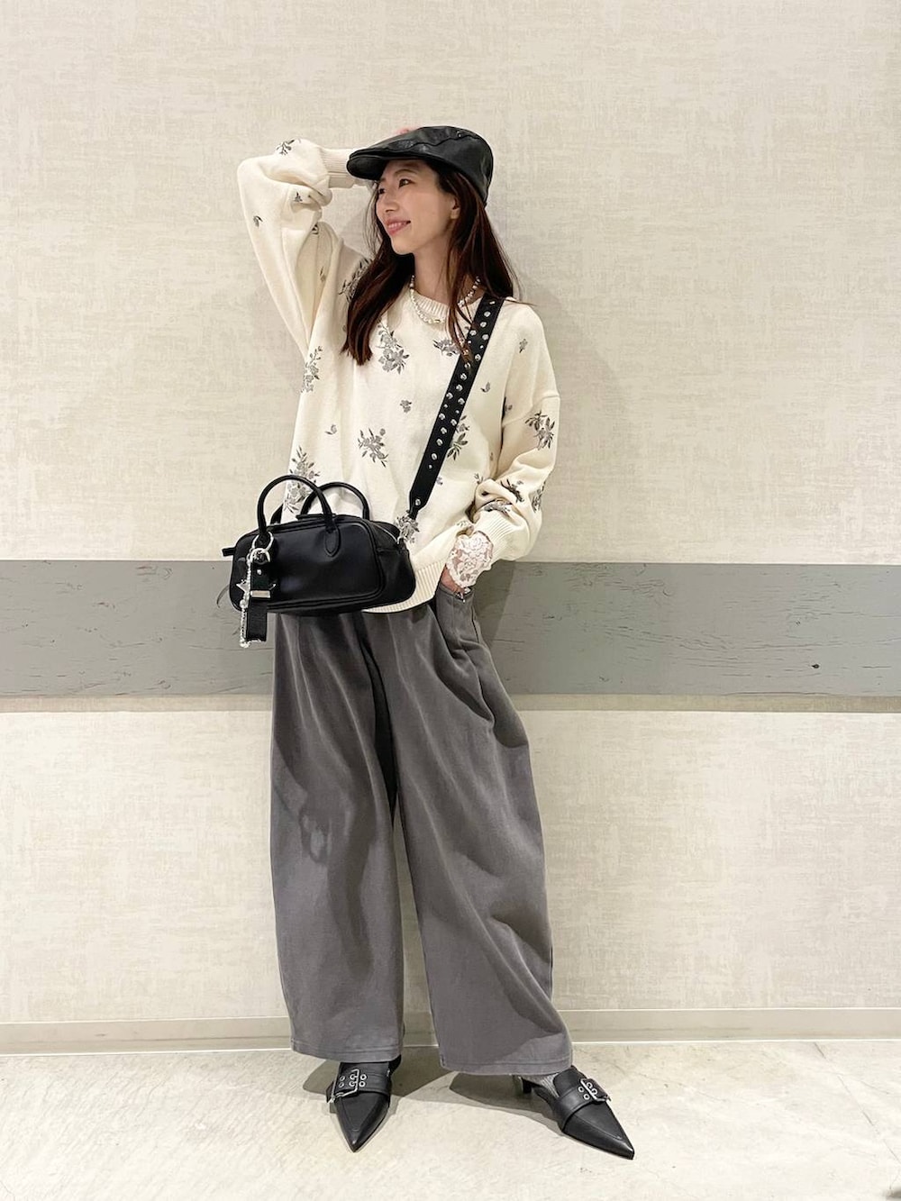 ブラック系のボストンバッグ、ブラック系のパンプス、ホワイト系のニット/セーターを着用したレディースの春コーディネートの3枚目の写真