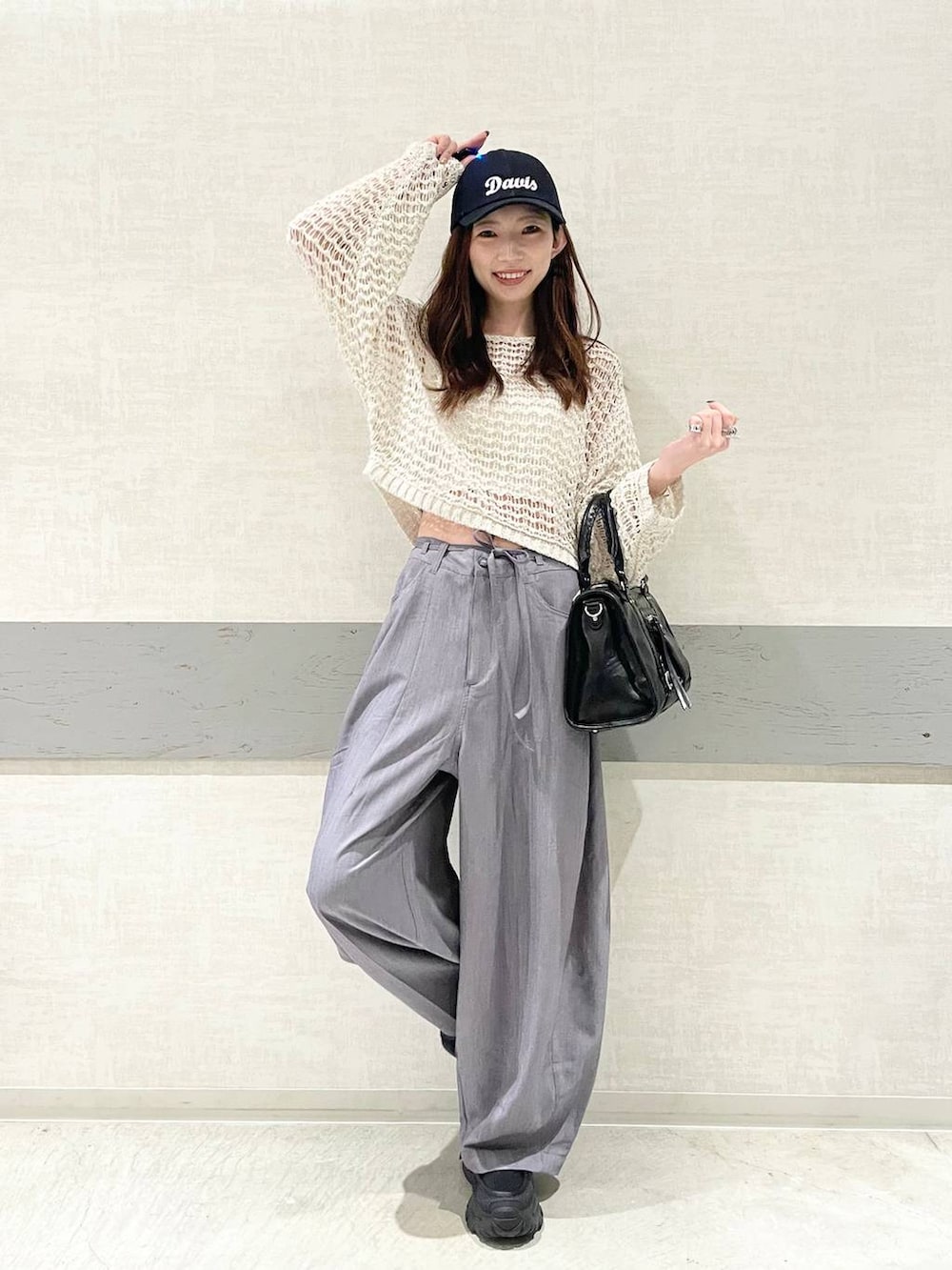 ブラック系のローファー、ブラック系のボストンバッグ、ピンク系のニット/セーターを着用したレディースの春コーディネートの2枚目の写真