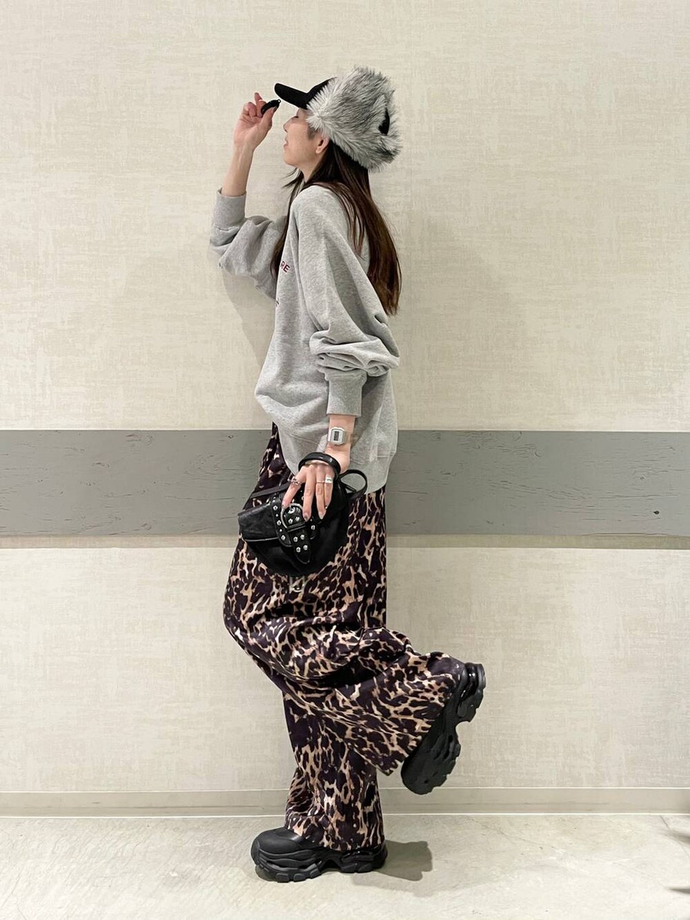 ブラック系のブーツ、ブラック系のショルダーバッグ、グレー系のスウェットを着用したレディースの冬コーディネートの4枚目の写真