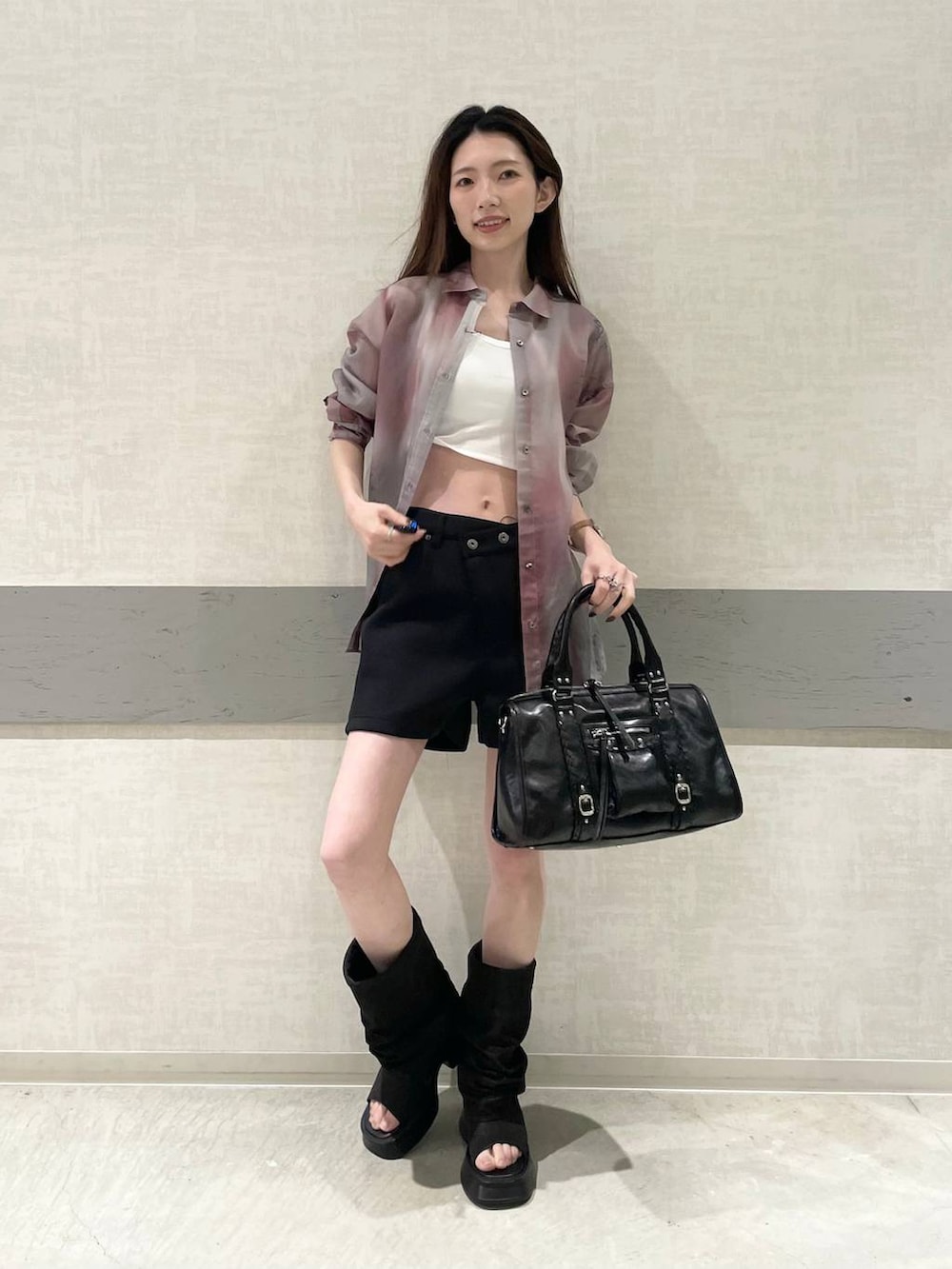 ホワイト系のタンクトップ、ブラック系のスウェットパンツ、ブラック系のボストンバッグを着用したレディースの春コーディネートの3枚目の写真