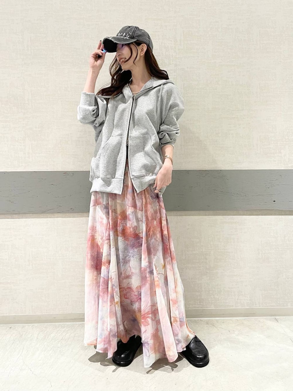 ブラック系のローファー、グレー系のパーカー、レッド系のスカートを着用したレディースの春コーディネートの2枚目の写真