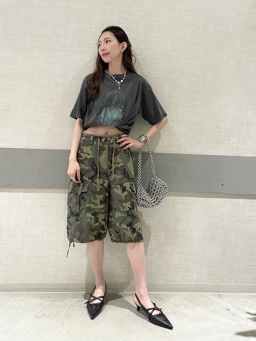 グレー系のTシャツ/カットソー、シルバー系のハンドバッグ、ブラック系のパンプスを着用したレディースの夏コーディネートの4枚目の写真