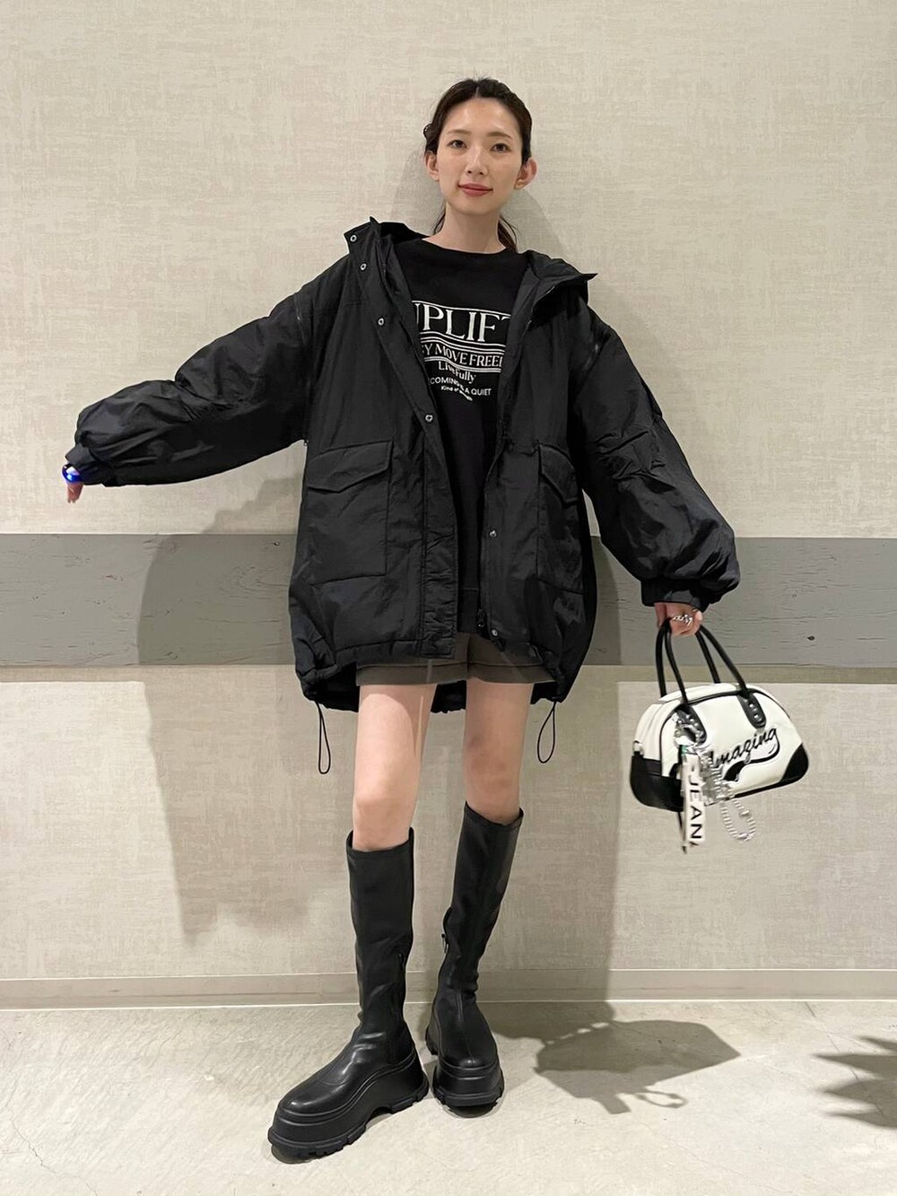 ブラック系のブルゾン、ホワイト系のショルダーバッグ、グレー系のその他パンツを着用したレディースの秋コーディネートの4枚目の写真