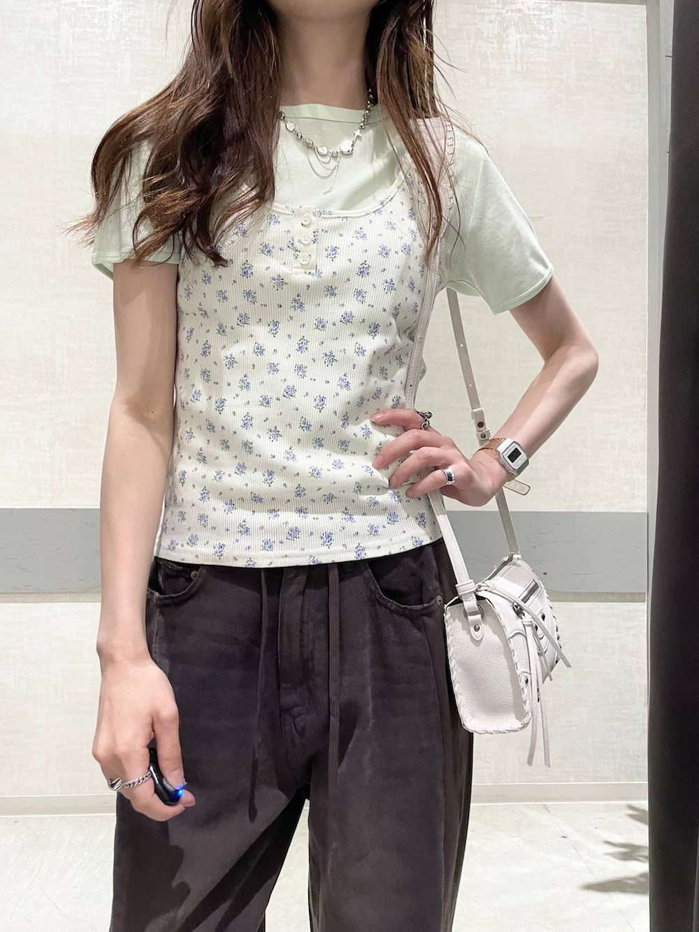 ブラウン系のデニムパンツ、ブラック系のパンプス、ホワイト系のタンクトップを着用したレディースの夏コーディネートの6枚目の写真