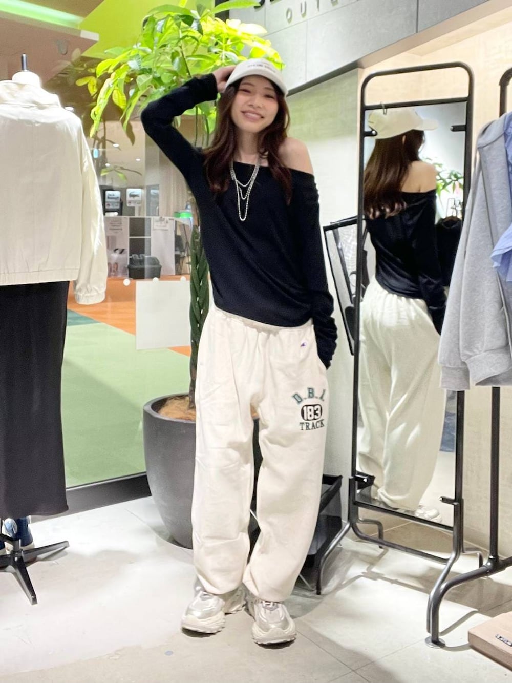 シルバー系のスニーカー、ブラック系のTシャツ/カットソー、ベージュ系のスウェットパンツを着用したレディースの春コーディネートの3枚目の写真